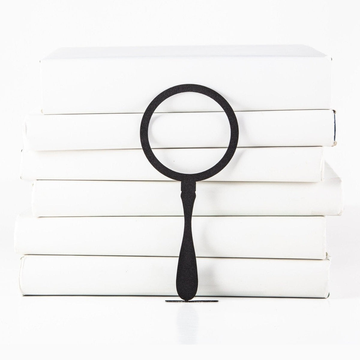 Magnifying Glass metal bookmark shown with a stack of books