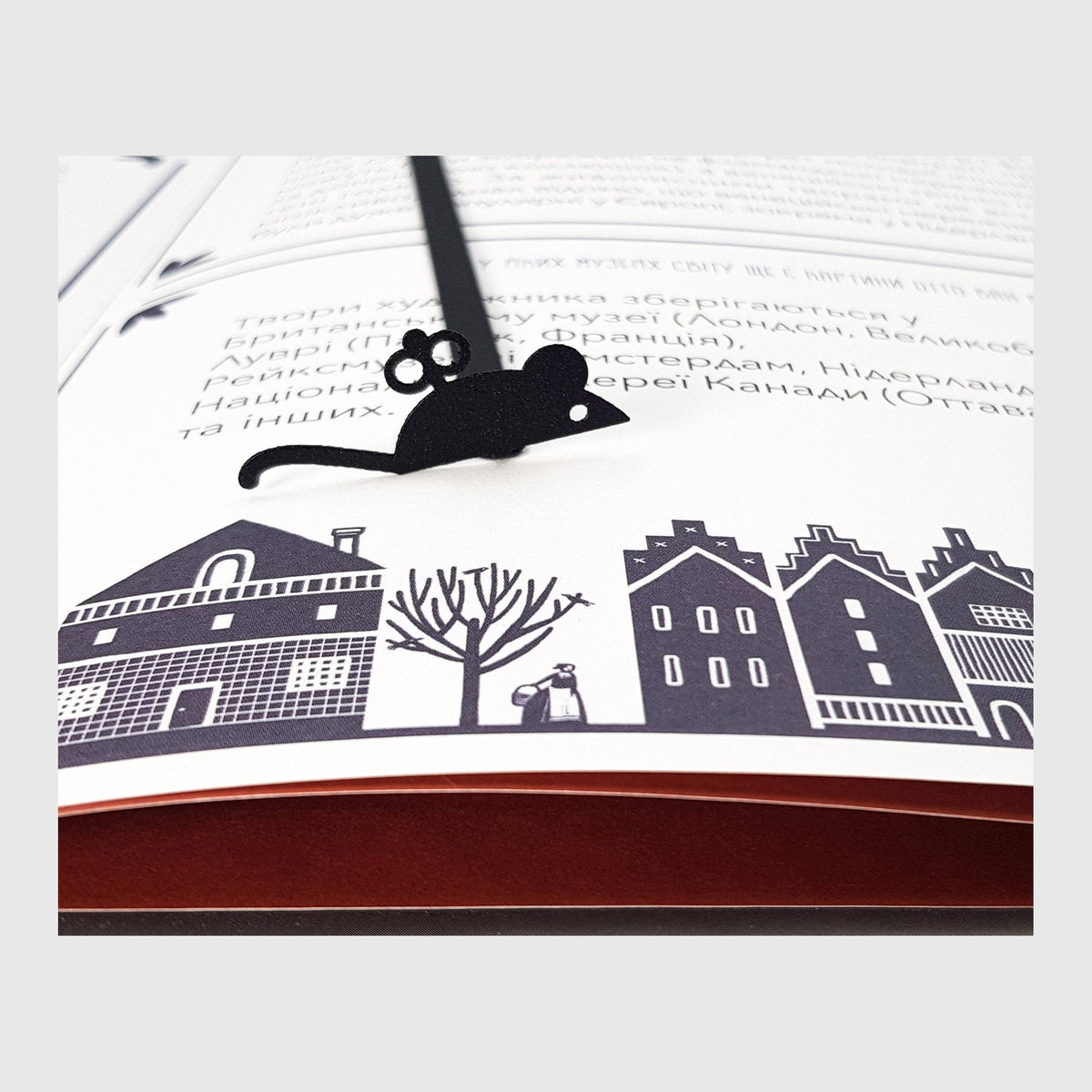 Mechanical Mouse metal bookmark marking a page in an illustrated book