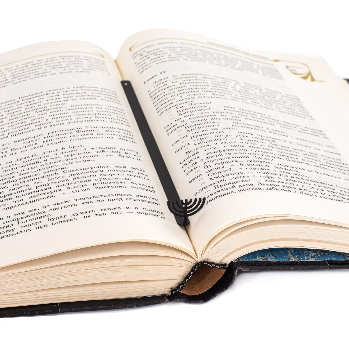 Menorah metal bookmark resting on the pages of an open book