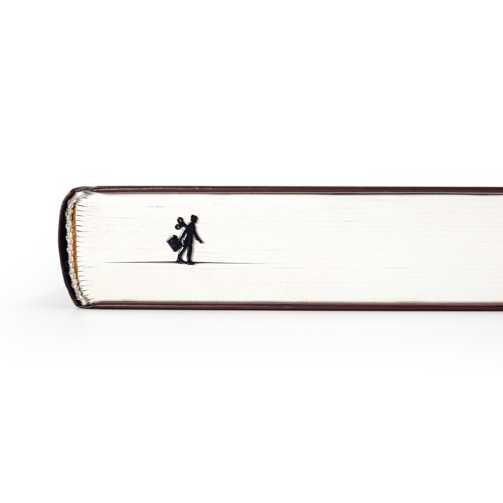 Black metal bookmark shaped like a walking businesswoman with a wind-up key, visible along the edge of a closed book.