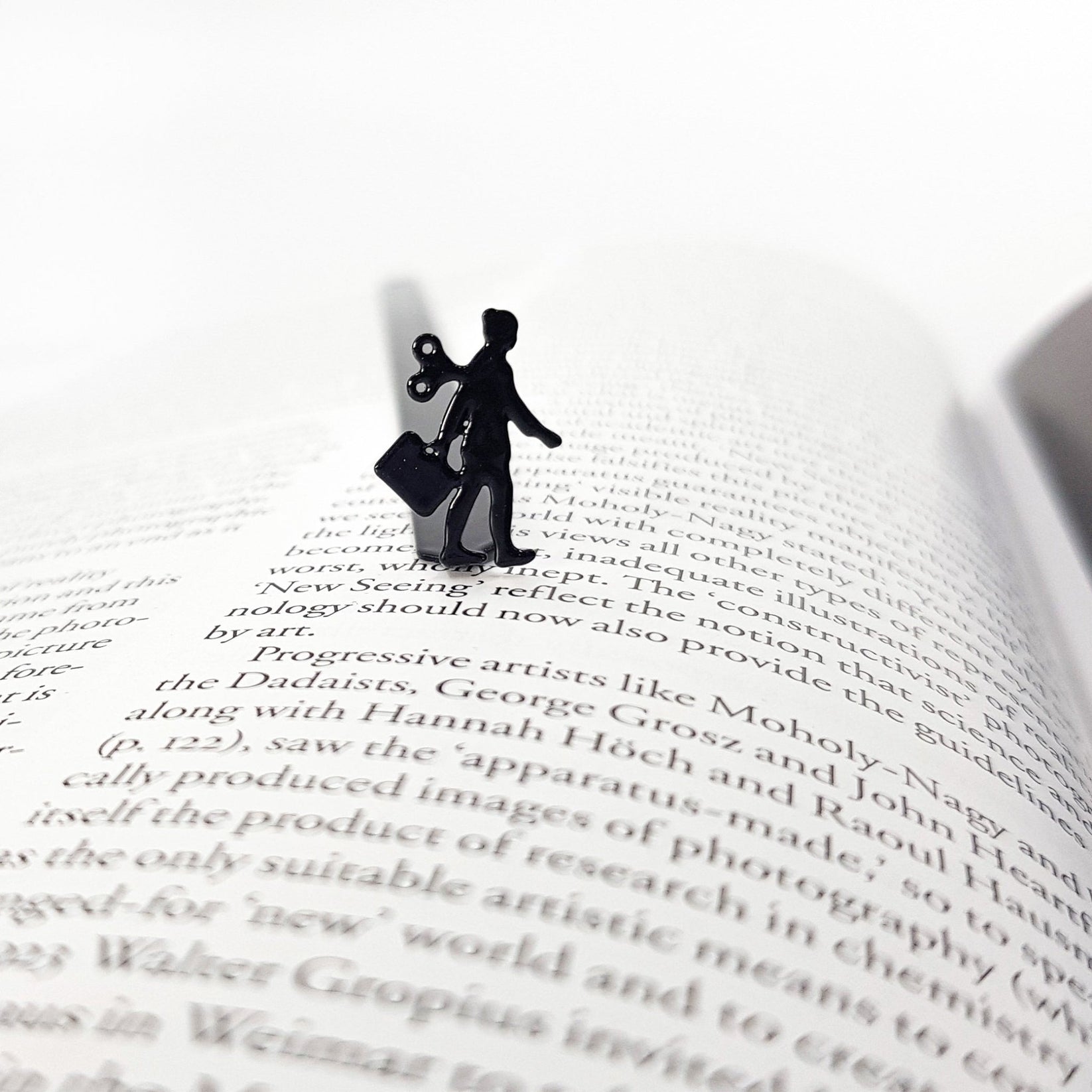 Black metal bookmark featuring a business woman silhouette resting on an open book page