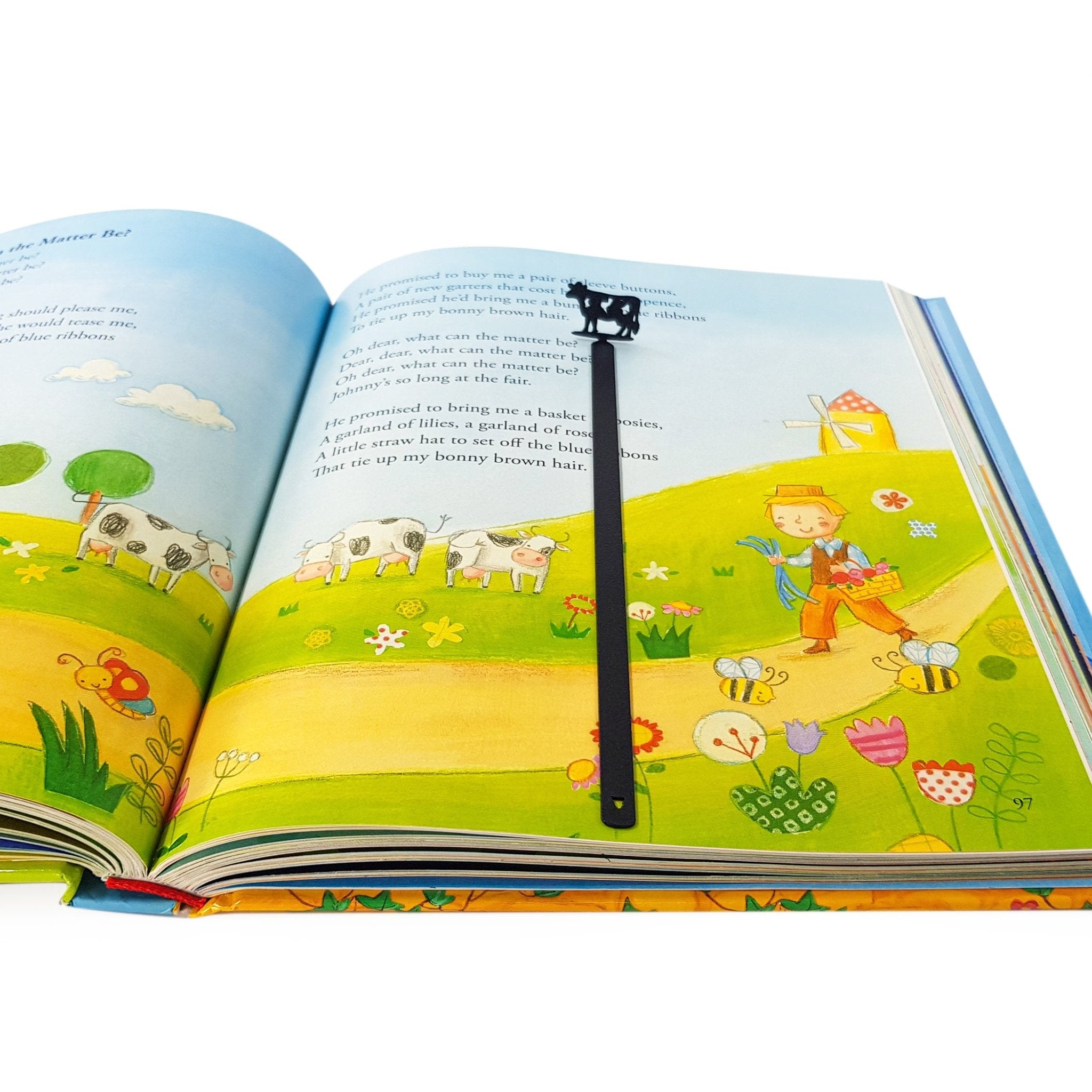 Black steel cow bookmark clipped over page in colorful illustrated children's book