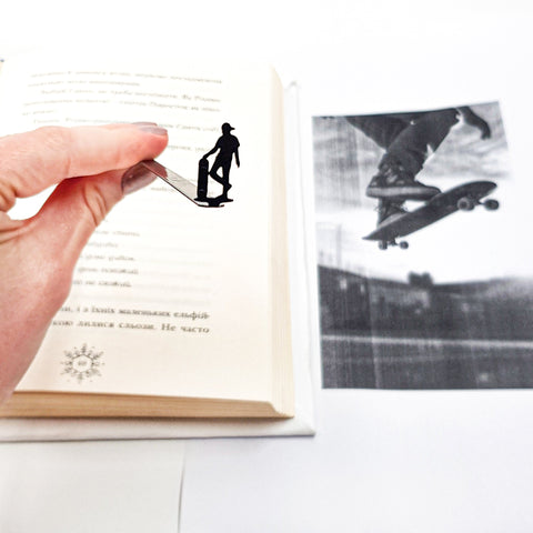 Metal Skater bookmark held in a hand above an open book