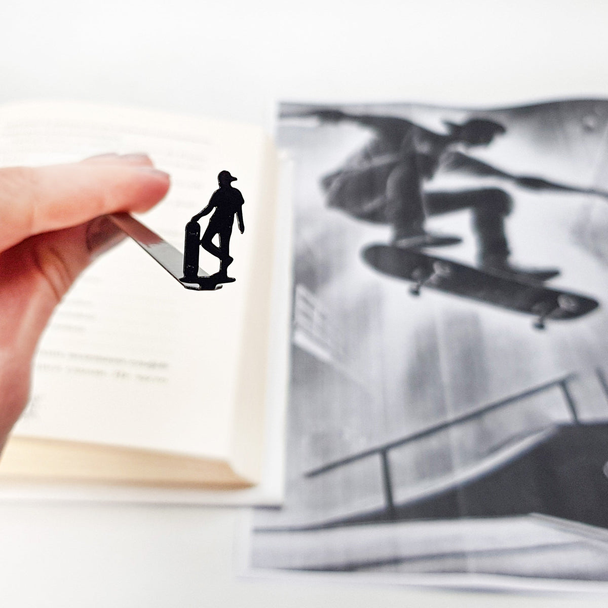Metal Skater bookmark held up beside an open book
