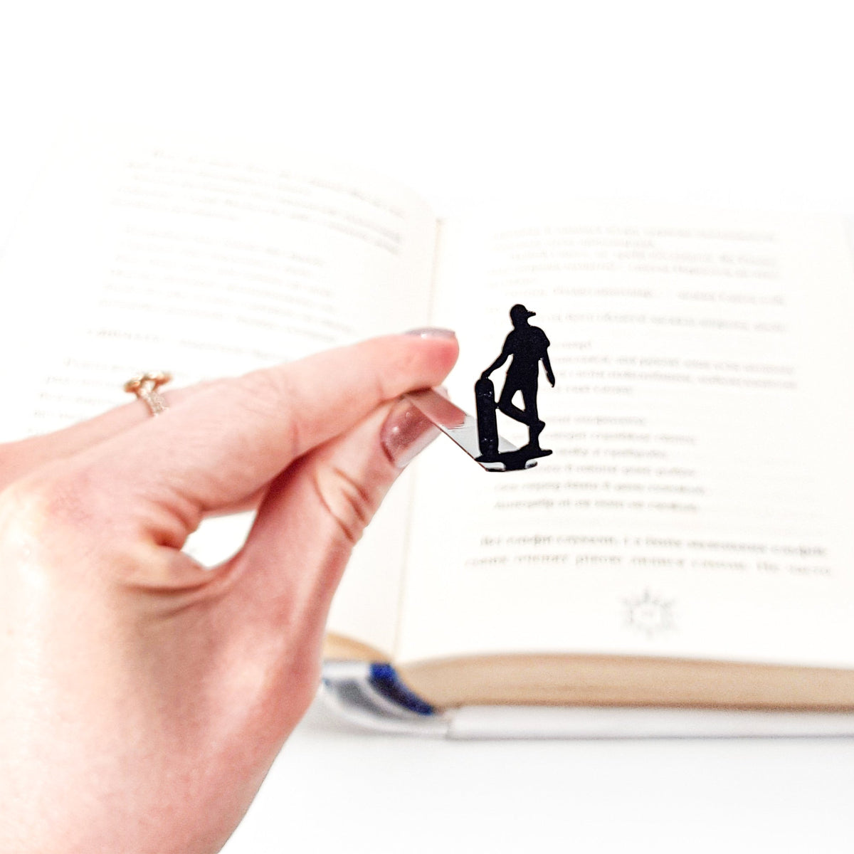 Metal Skater bookmark held in a hand to show its size