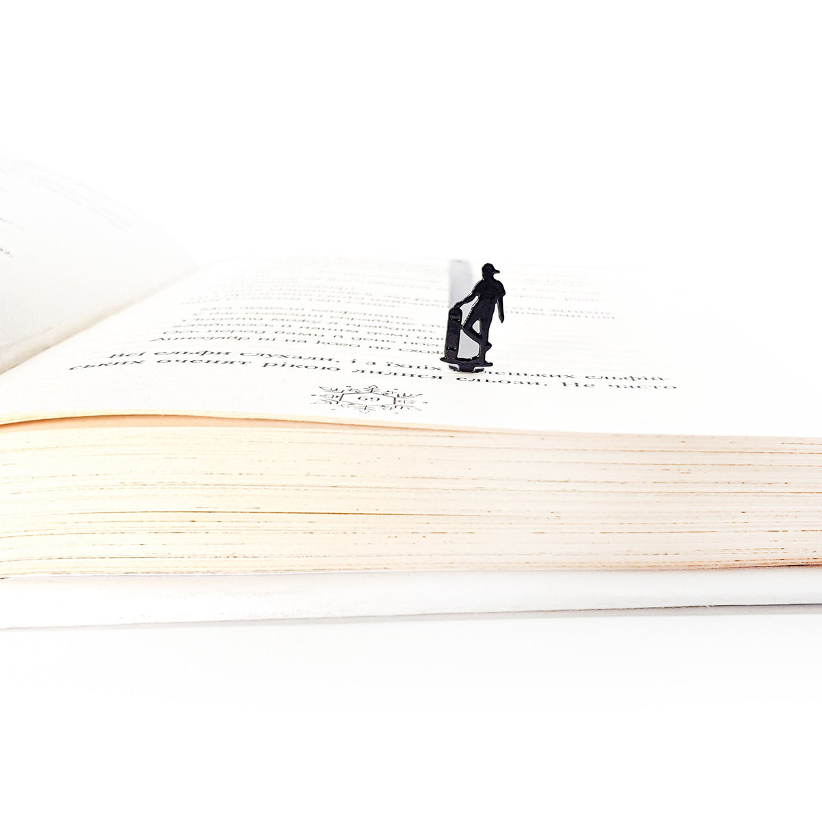 Metal Skater bookmark marking a page in an open book