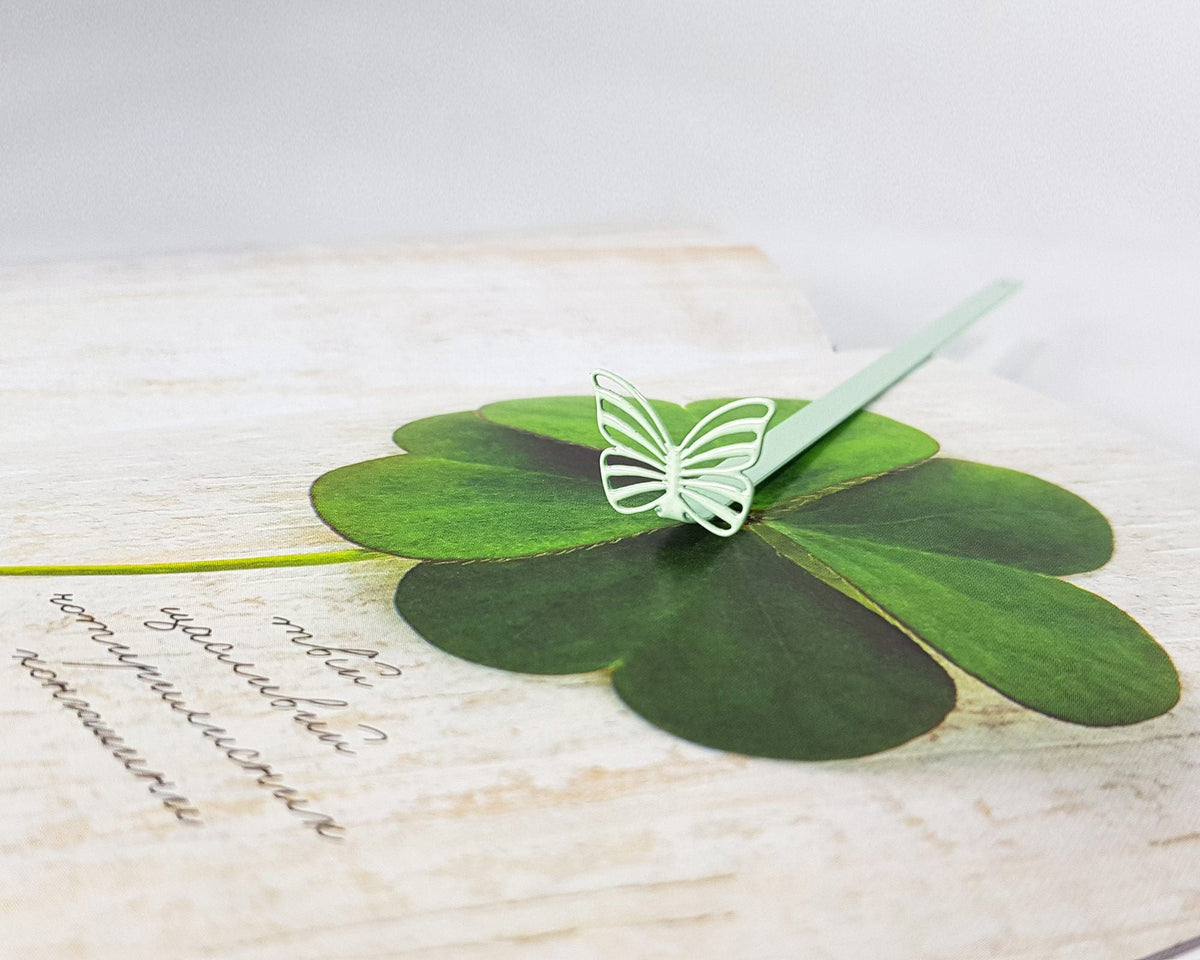 Mint Butterfly metal bookmark in green against a coloured backdrop