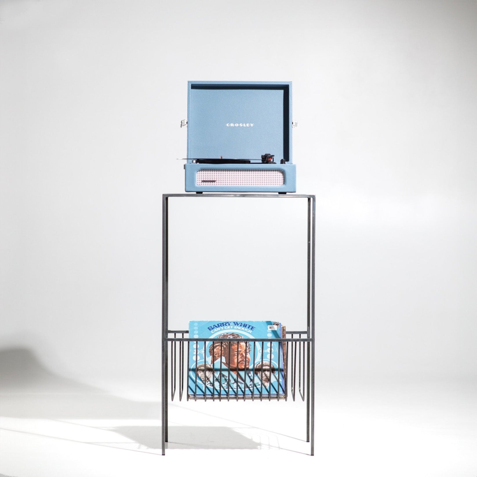 Front view of metal record player stand with turntable and vinyl records below