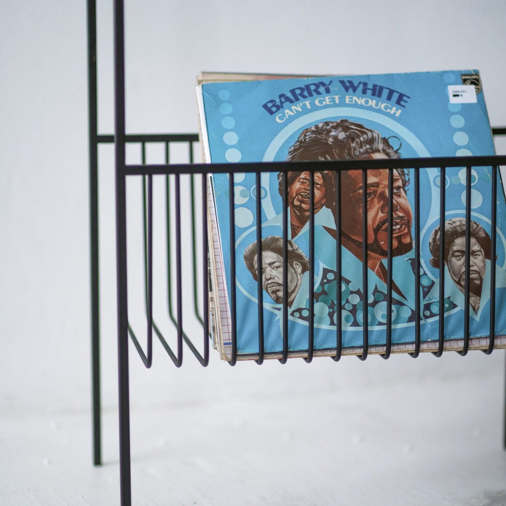 Close-up of black wire LP storage basket holding upright vinyl records
