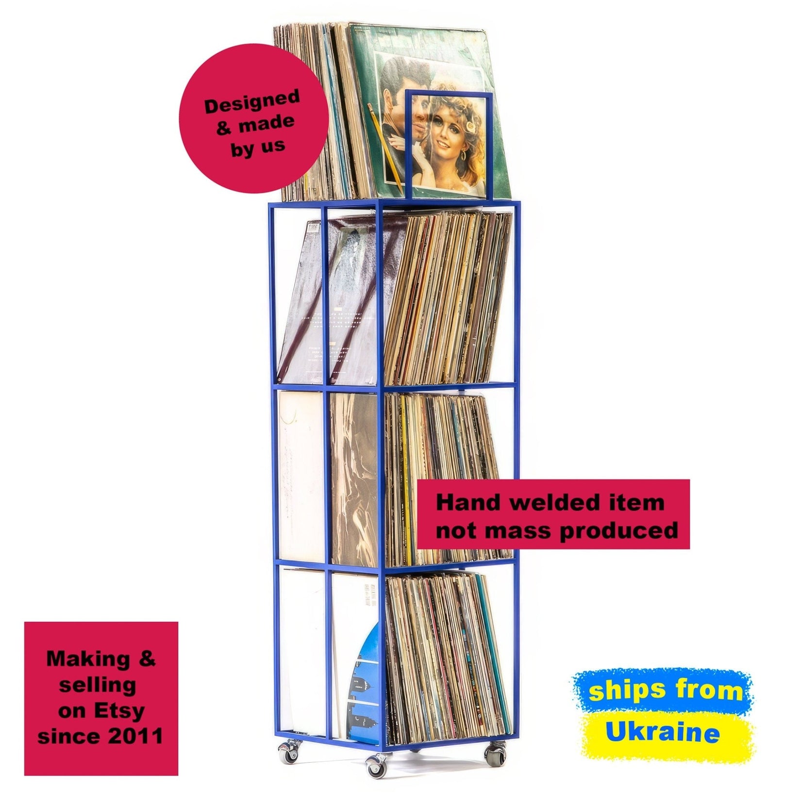 Tall blue metal vinyl record rack on wheels, hand-welded with four compartments, fully loaded with LP records and a featured album displayed on top.