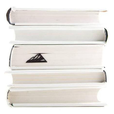 Mountain Climber metal bookmark shown with a stack of books