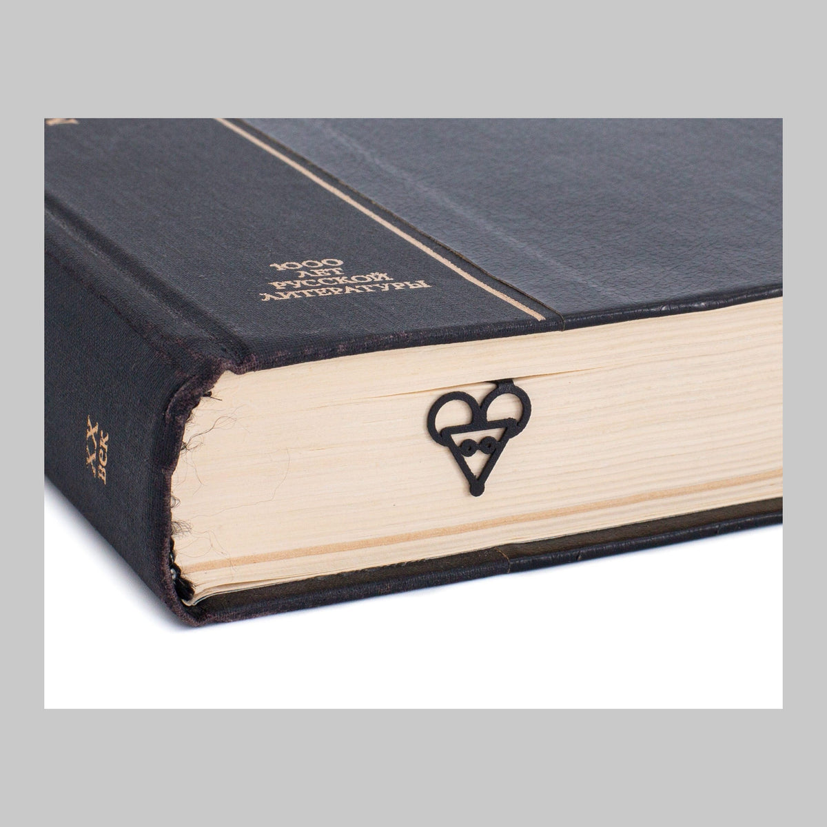 Mouse Head metal bookmark in a closed book, only its top showing above the pages