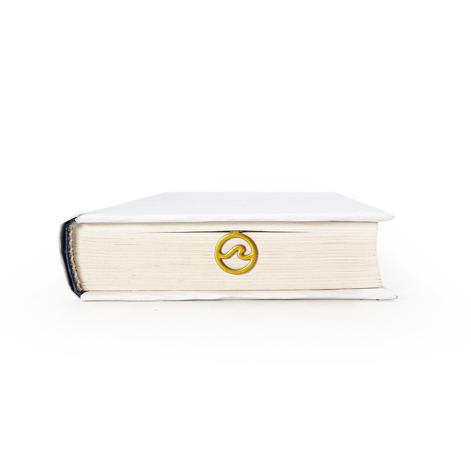 Nautical Big Wave metal bookmark in gold in a closed book, only its top showing above the pages