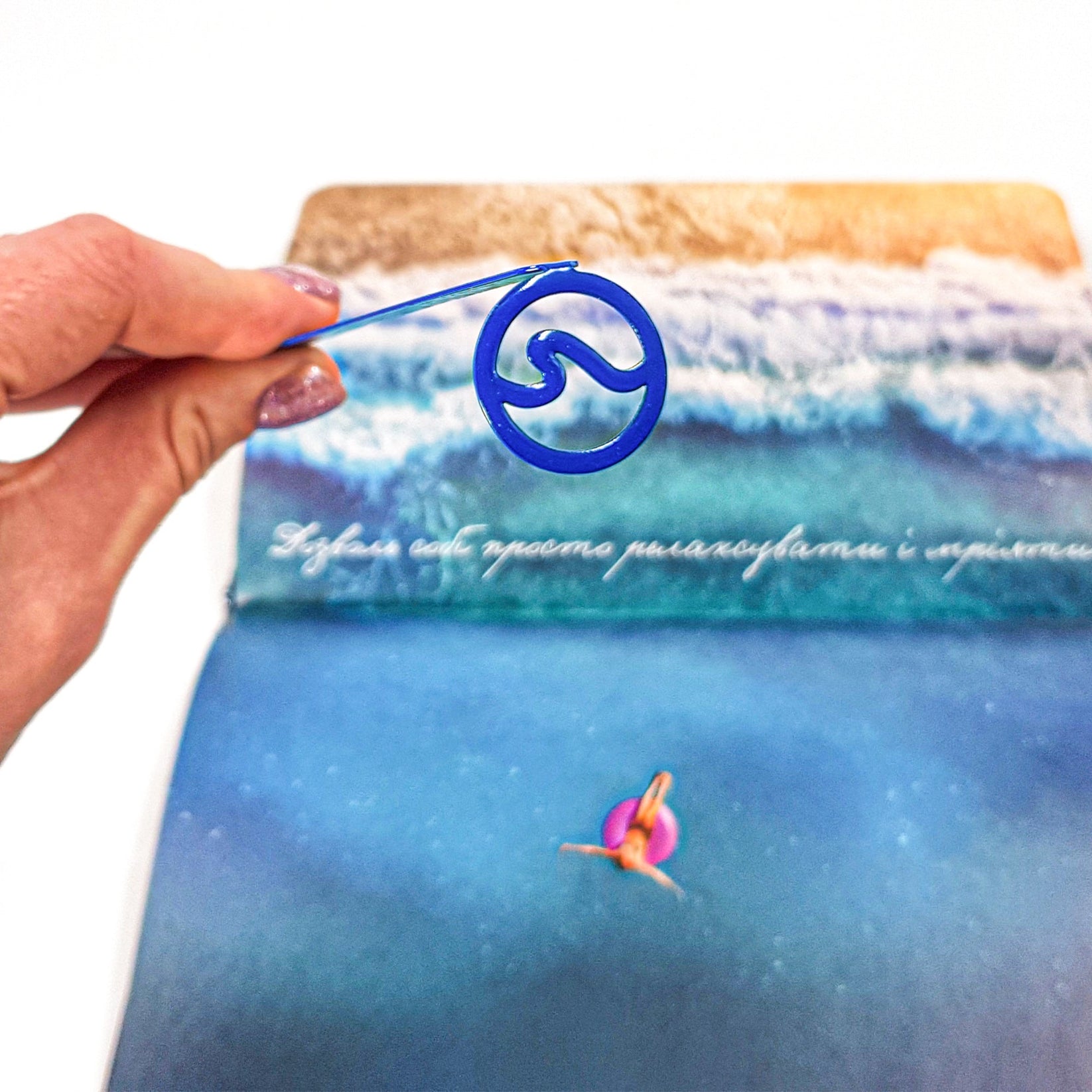 Nautical Big Wave metal bookmark in blue marking a page in an illustrated book