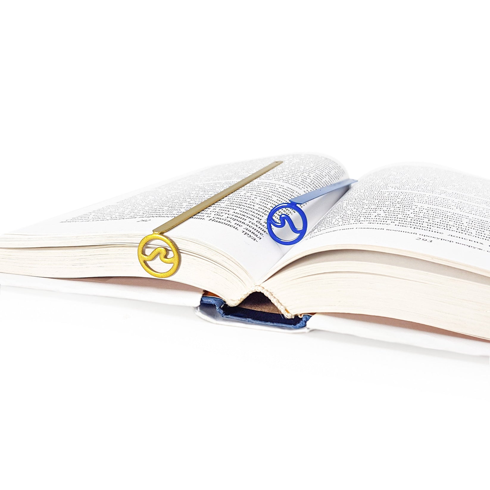 Nautical Big Wave metal bookmark in gold resting on the pages of an open book