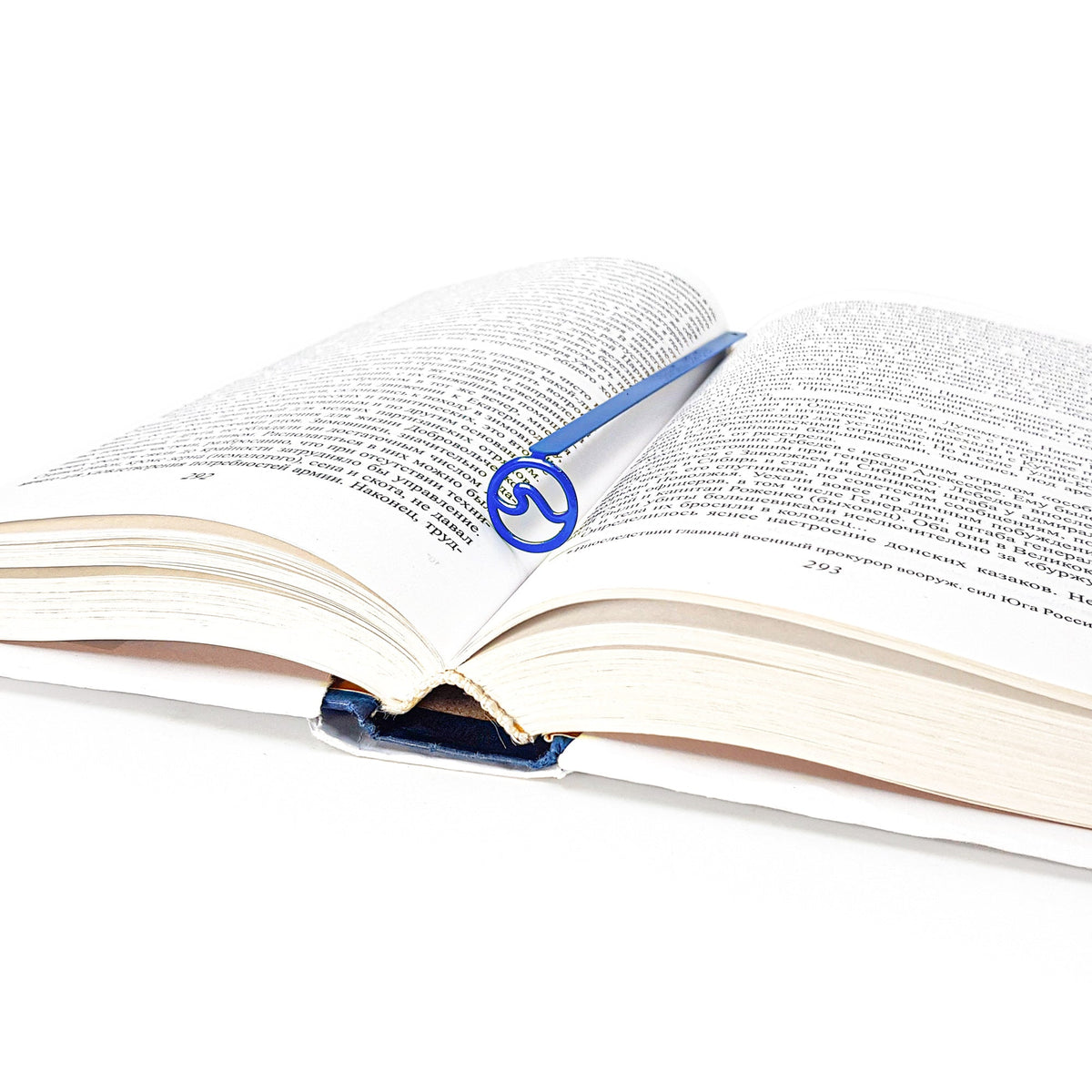 Nautical Big Wave metal bookmark in blue marking a page in an open book