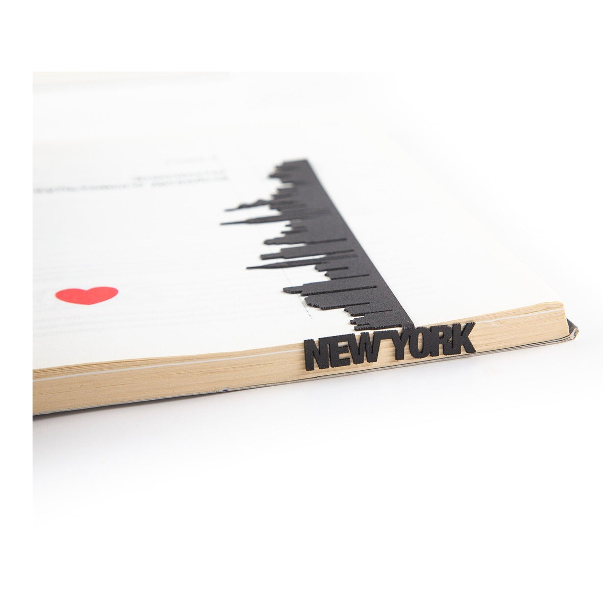 New York metal bookmark resting on the pages of an open book