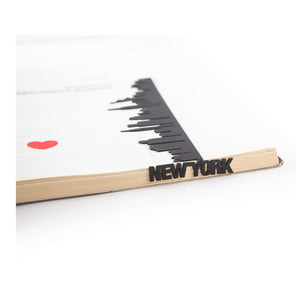 New York metal bookmark resting on the pages of an open book