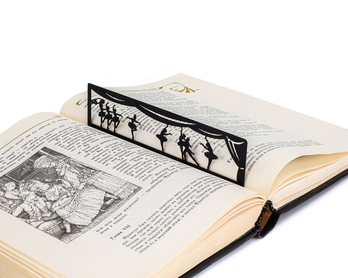 Ballet metal bookmark marking a page in an illustrated book