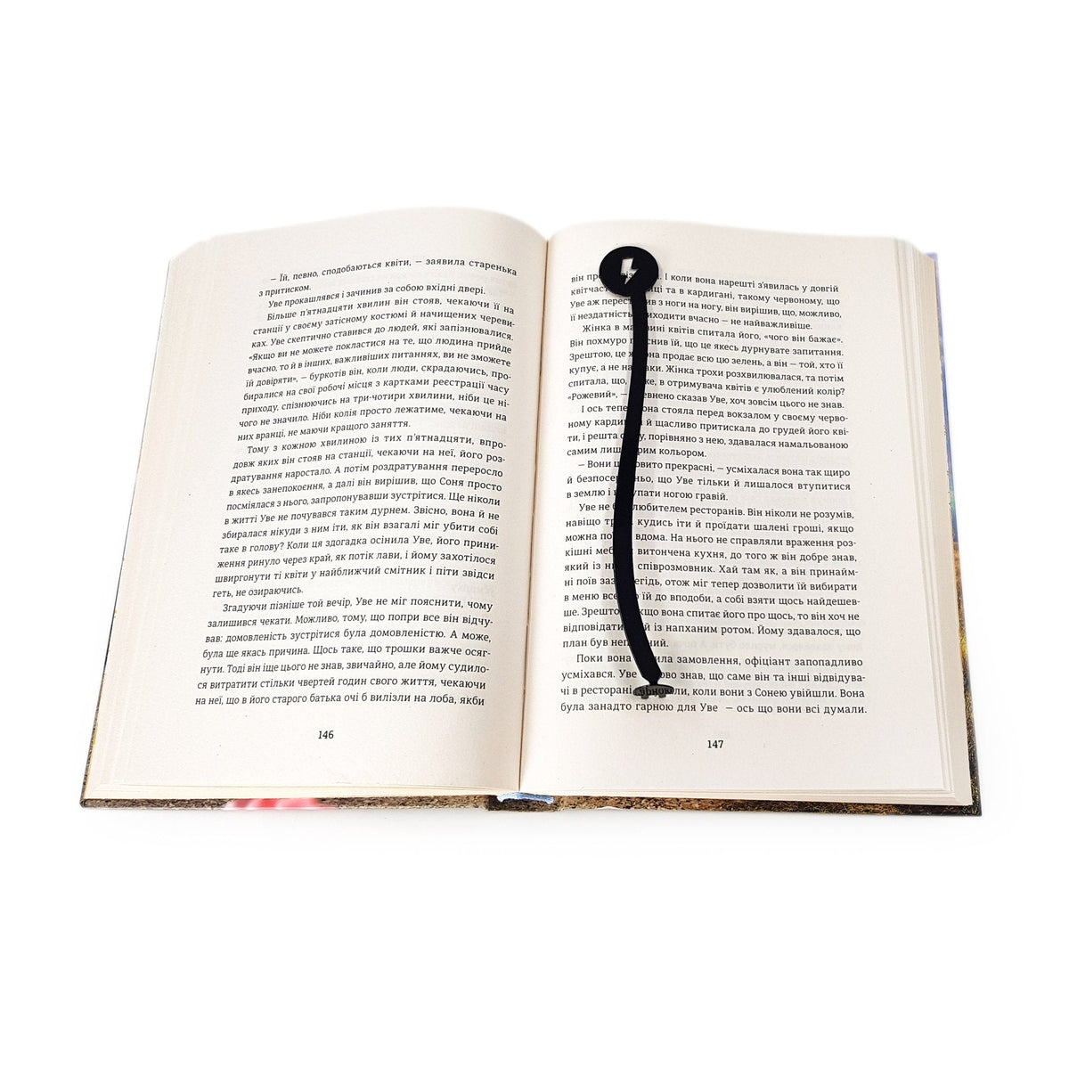 Electrical Plug metal bookmark lying across the pages of an open book