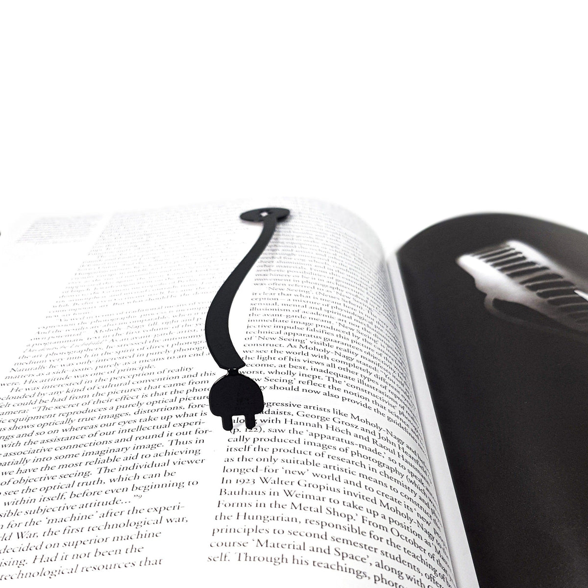 Electrical Plug metal bookmark resting on the pages of an open book