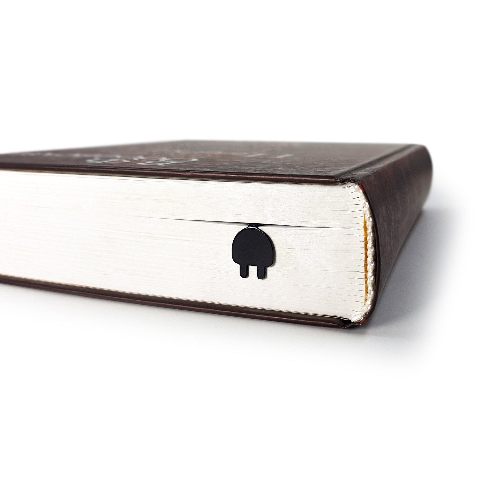Electrical Plug metal bookmark seen from the edge of a closed book