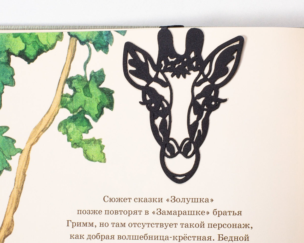 Giraffe Head metal bookmark marking a page in an illustrated book