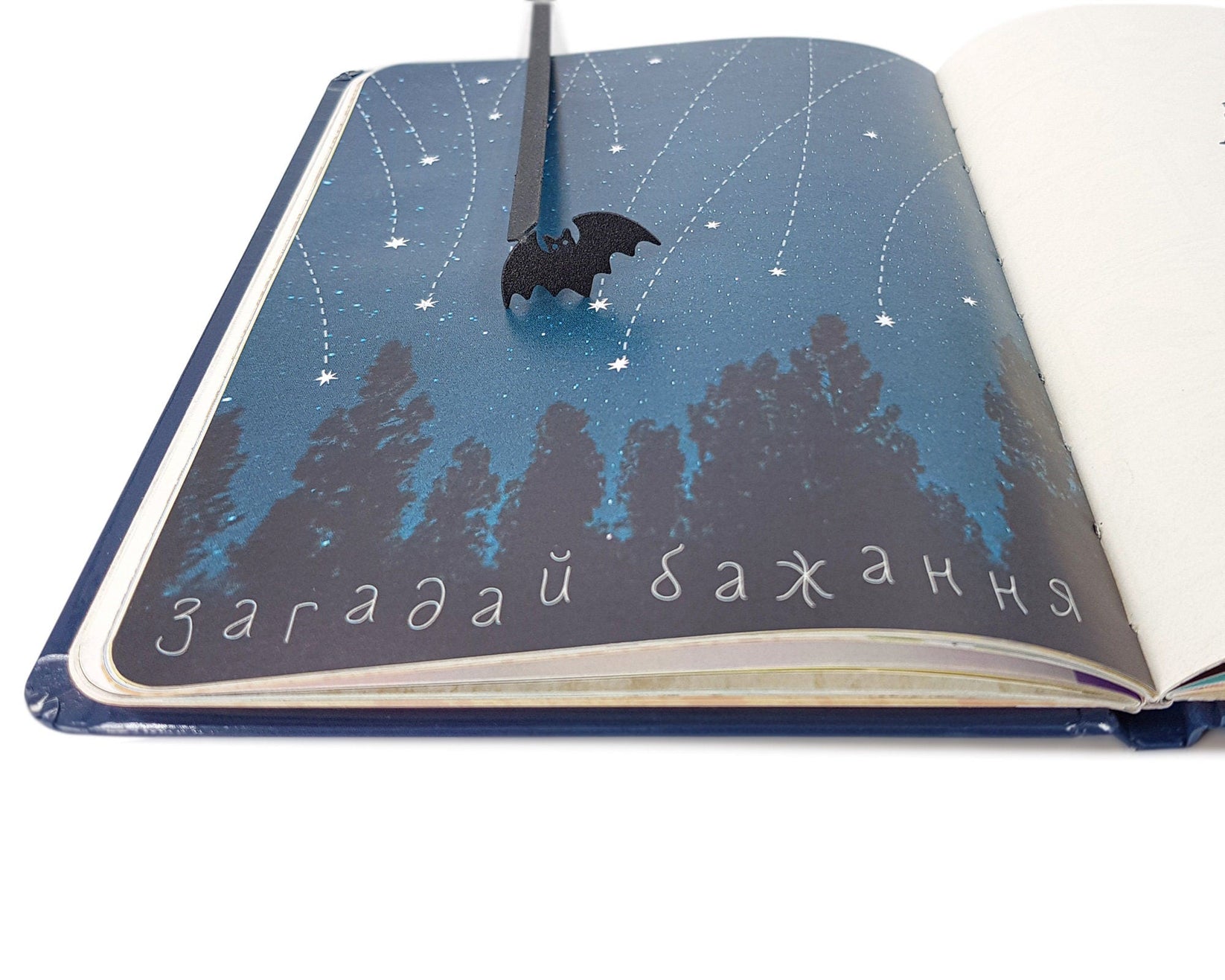 Kitti Bat metal bookmark placed on a colour illustration