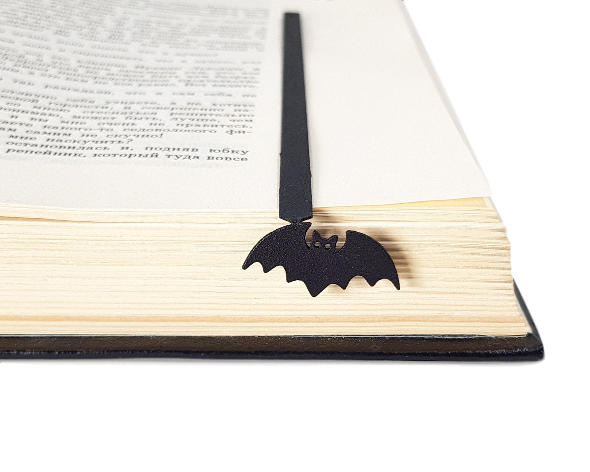 Kitti Bat metal bookmark marking a page in an open book