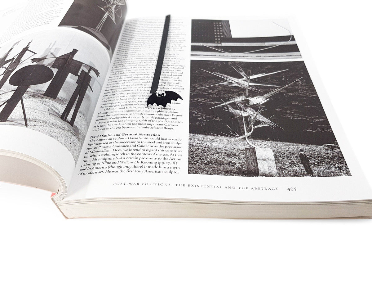 Kitti Bat metal bookmark marking a page in an illustrated book, view 4