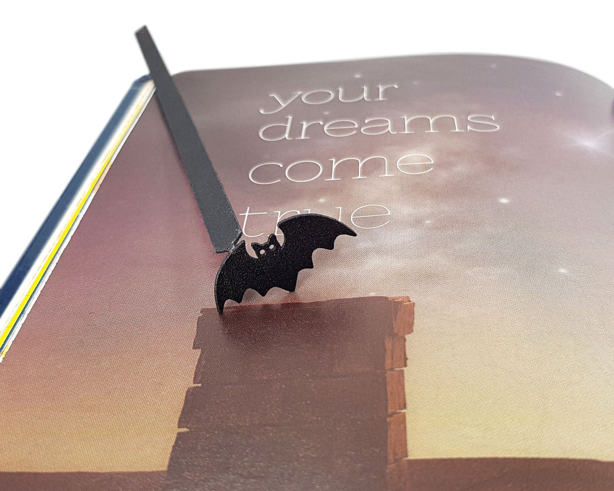 Kitti Bat metal bookmark on an illustrated page