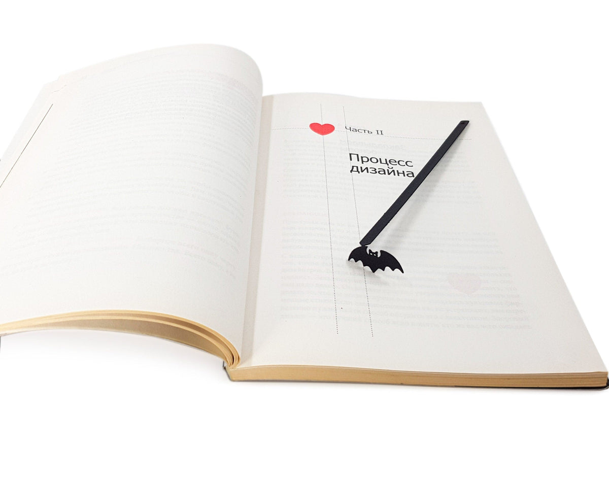 Kitti Bat metal bookmark marking a page in a notebook