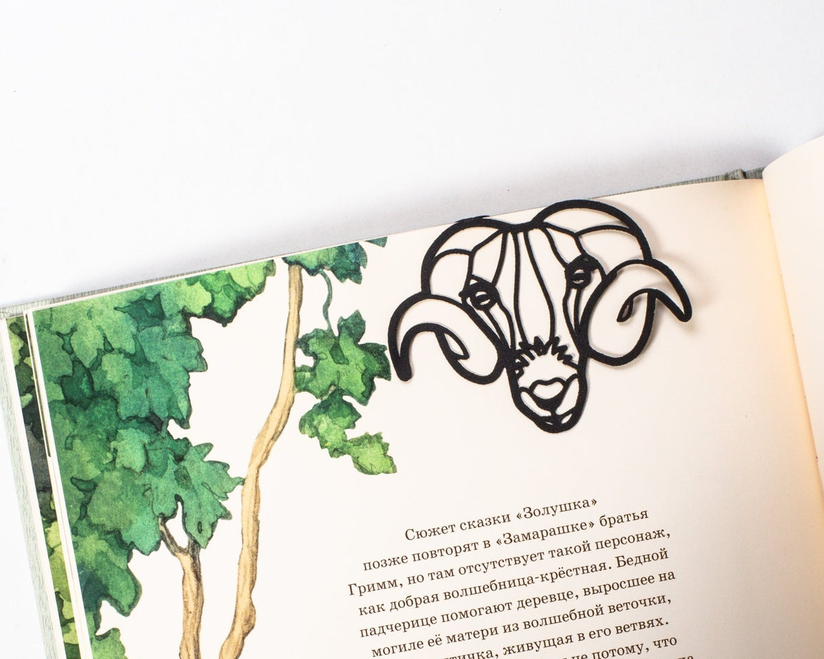 Ram's Head metal bookmark marking a page in an illustrated book