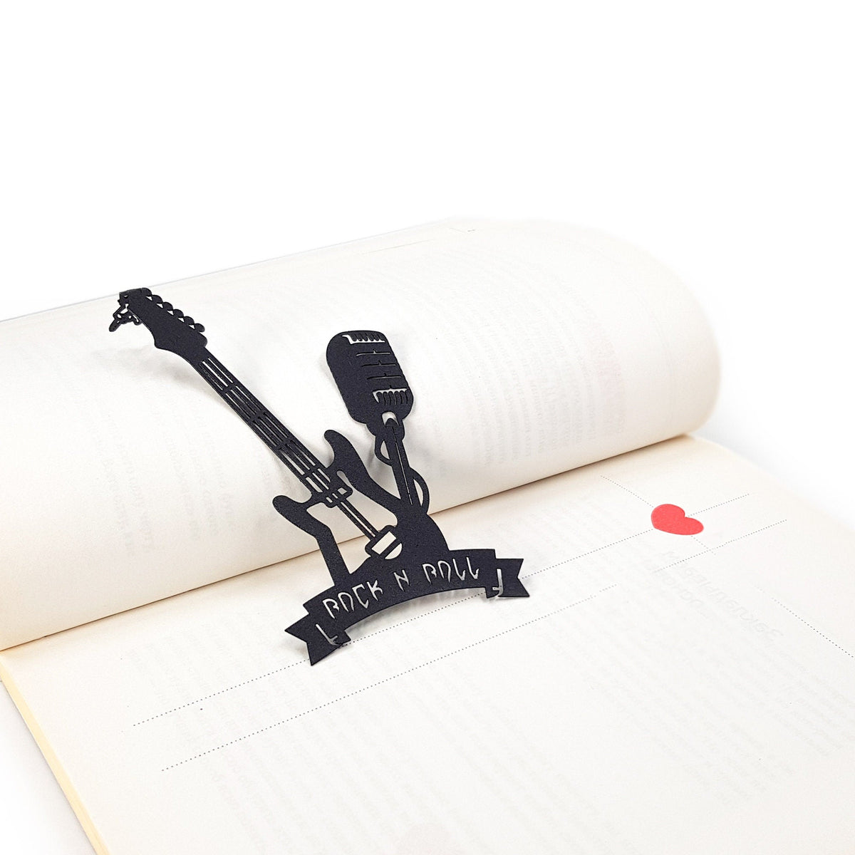 Rock and Roll metal bookmark resting on the pages of an open book