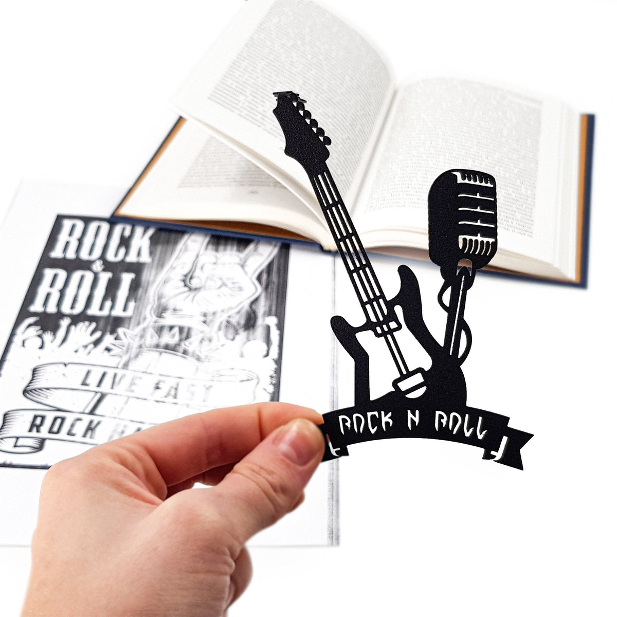 Rock and Roll metal bookmark marking a page in an illustrated book