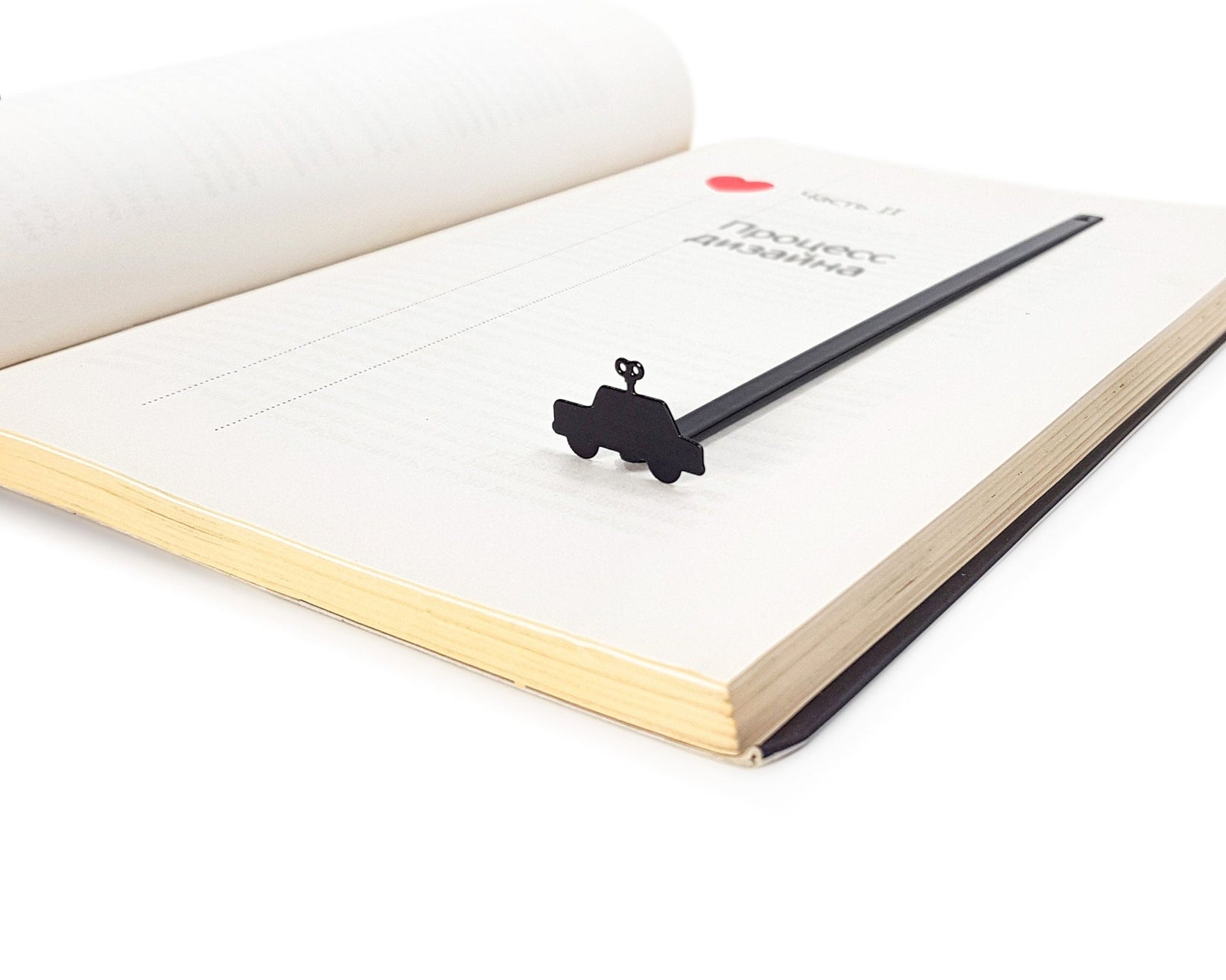 Wind-Up Toy Car metal bookmark resting on the pages of an open book