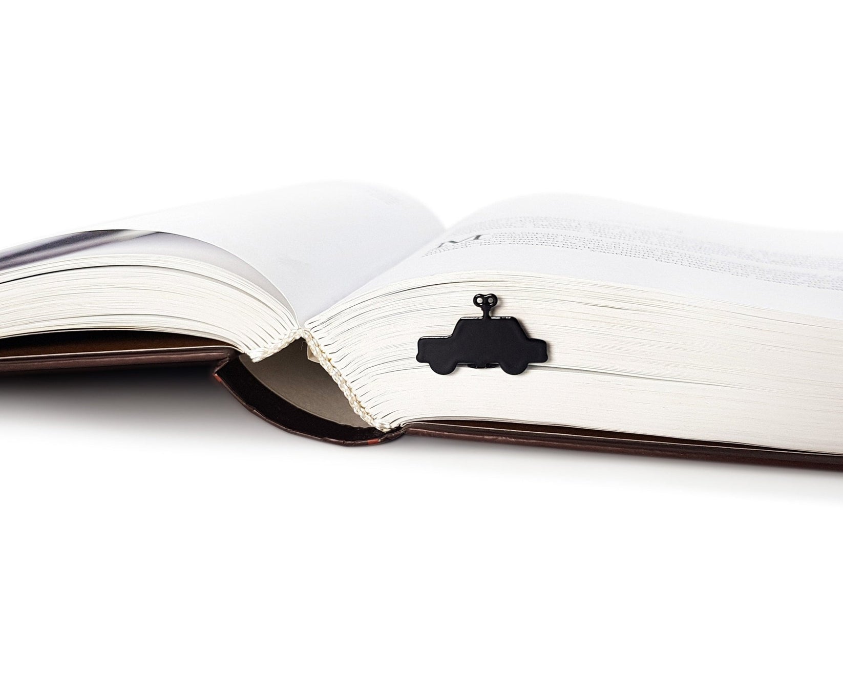 Wind-Up Toy Car metal bookmark marking a page in an open book
