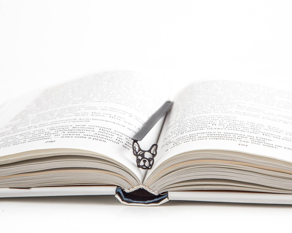 French Bulldog metal bookmark resting on the pages of an open book