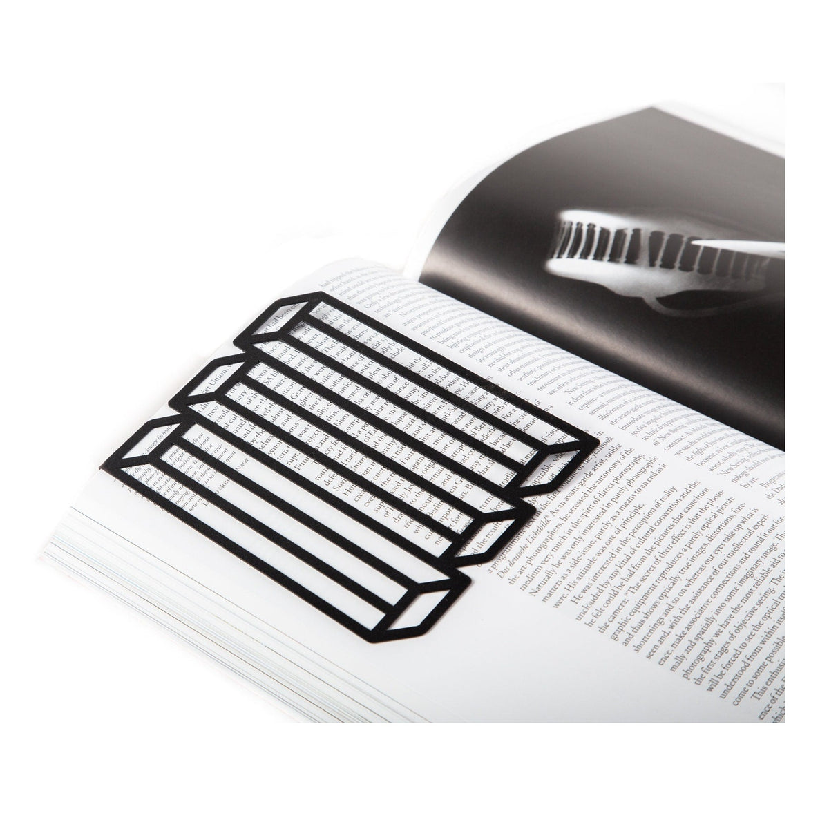 Optical Illusion metal bookmark resting on the pages of an open book