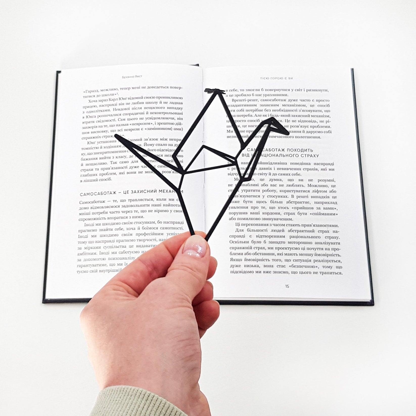 Origami Crane metal bookmark set into the gutter of an open book