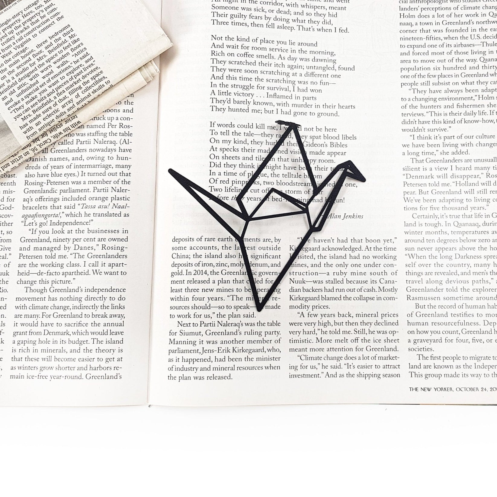 Origami Crane metal bookmark marking a page in an open book