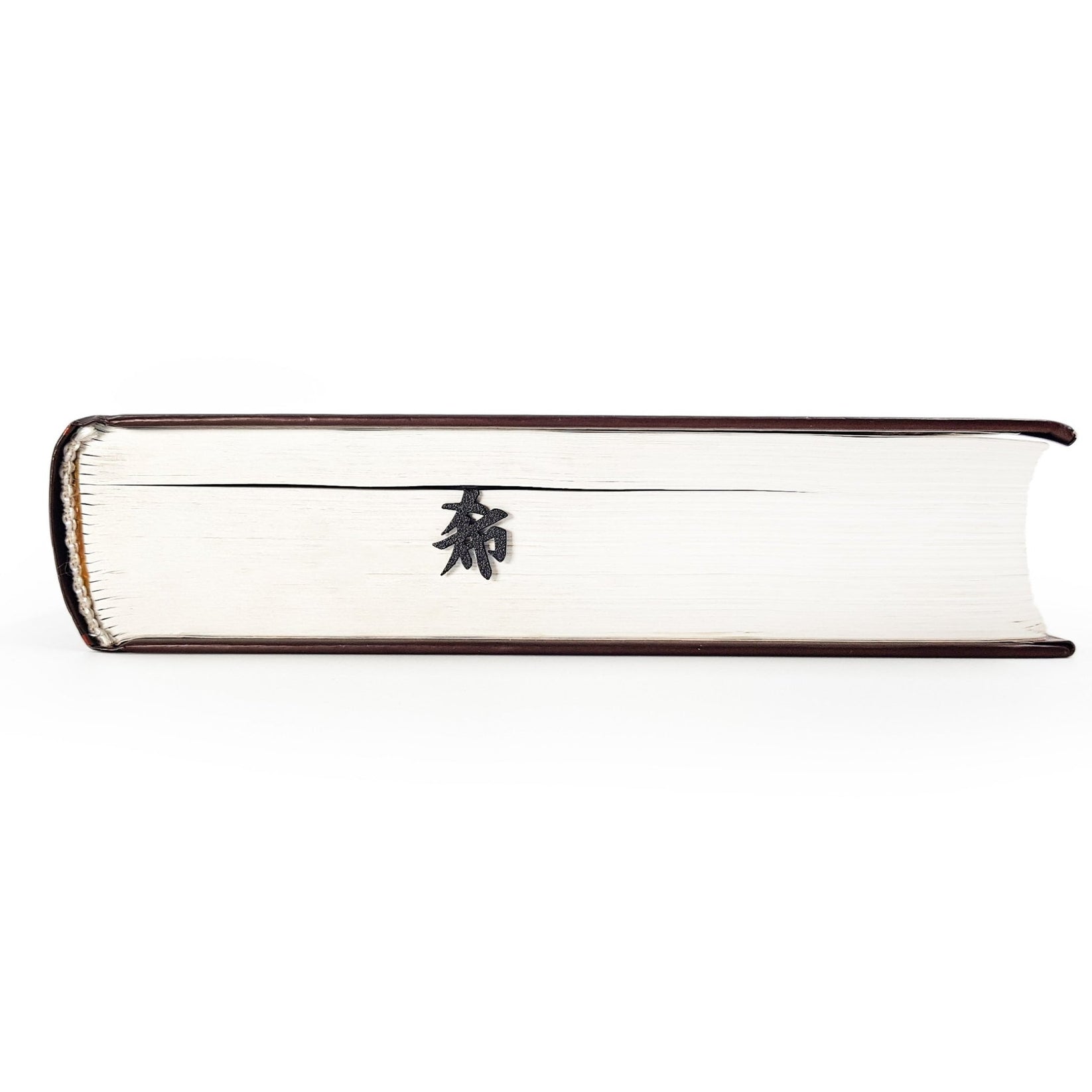 Origami Crane metal bookmark in a closed book, only its top showing above the pages
