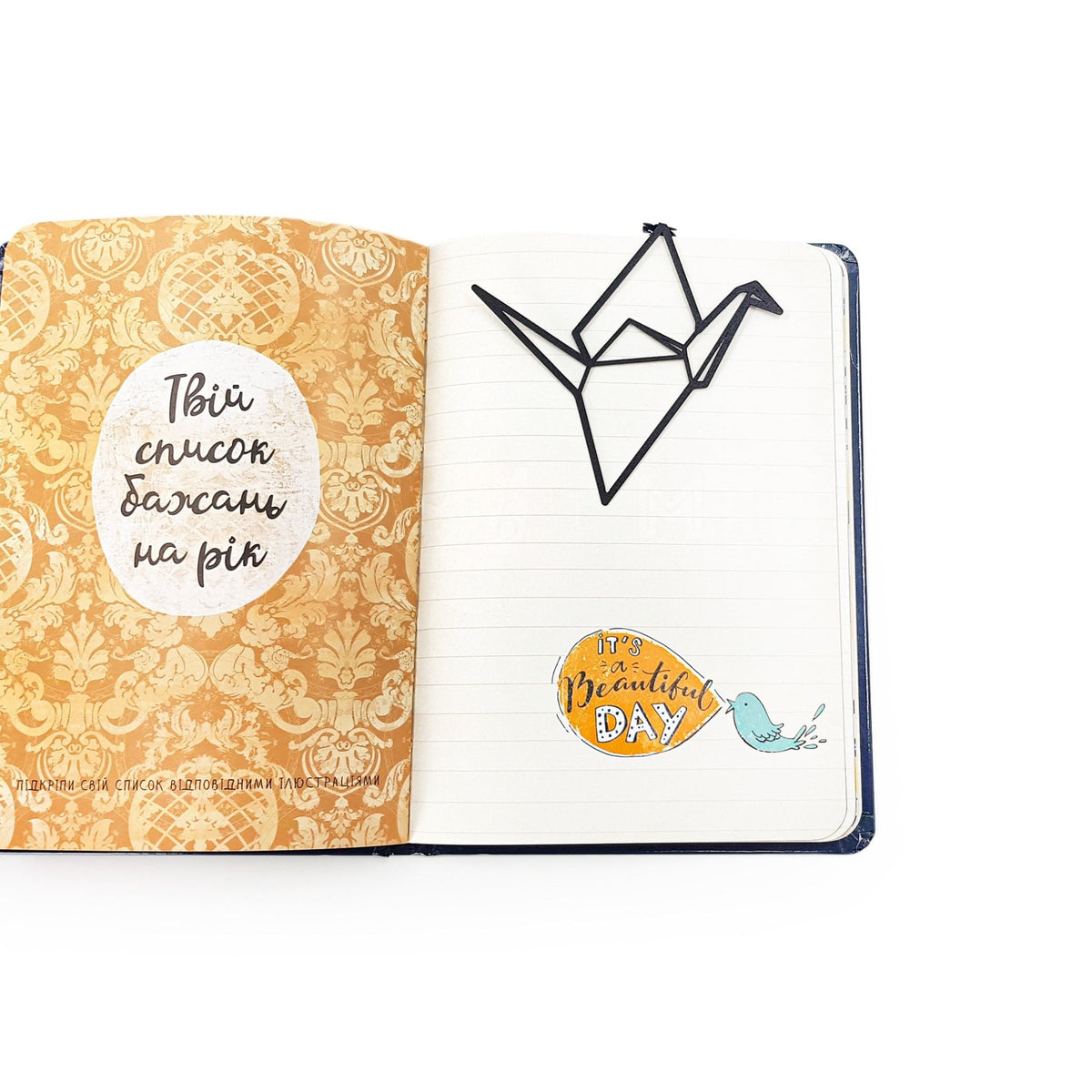 Origami Crane metal bookmark marking a page in a notebook