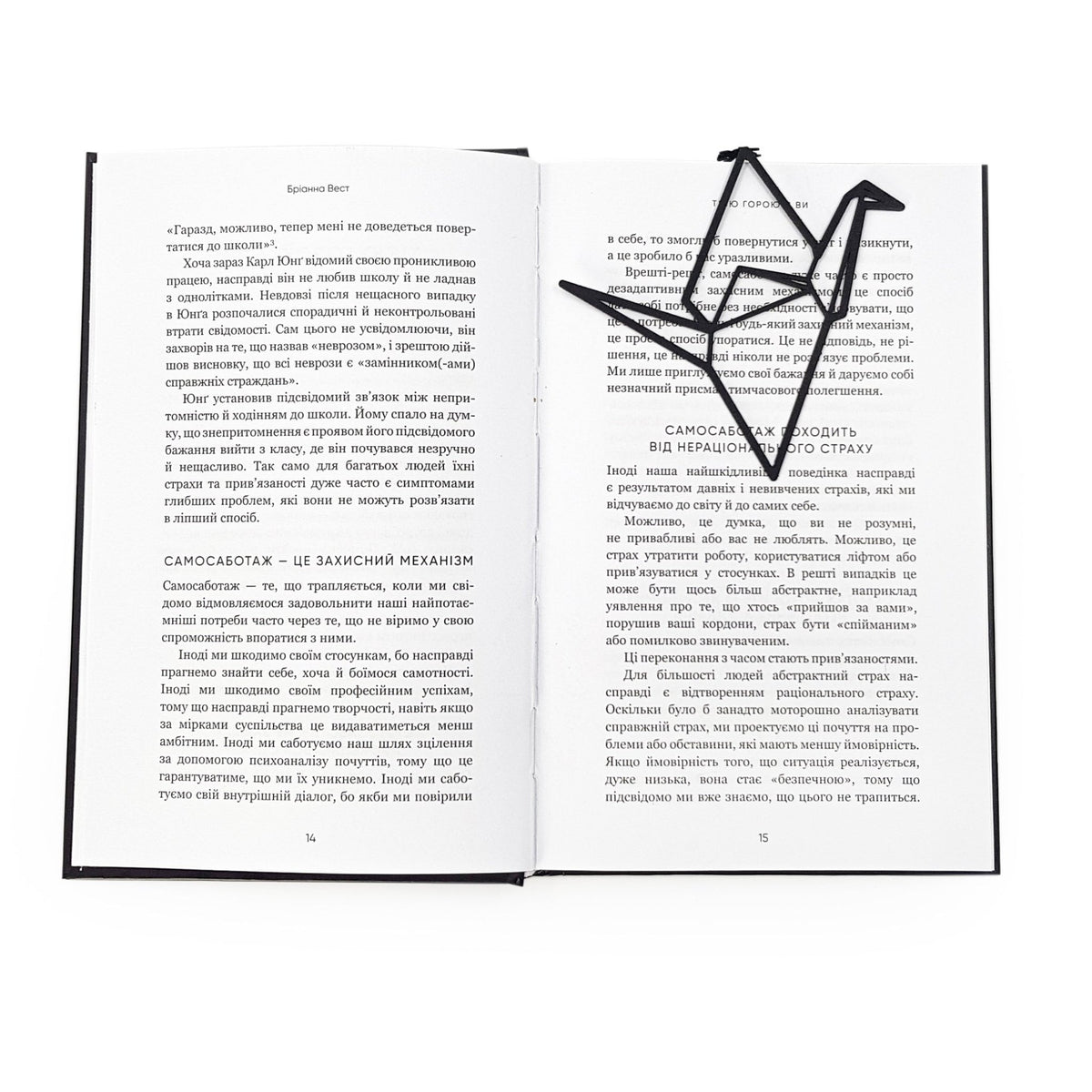 Origami Crane metal bookmark resting on the pages of an open book, view 5