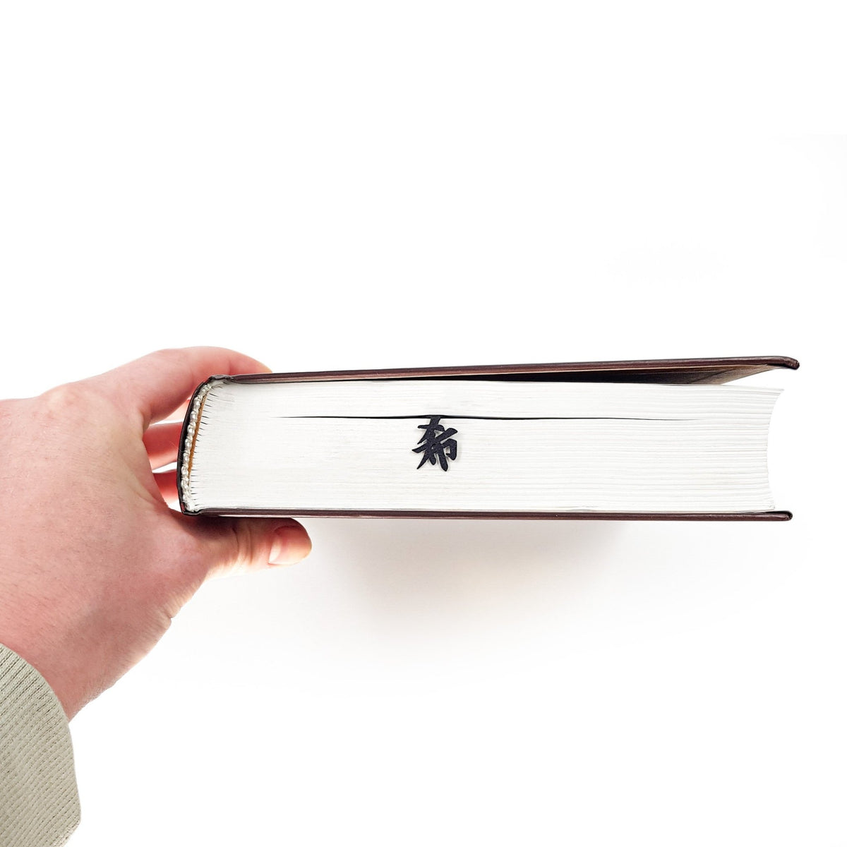 Origami Crane metal bookmark held in a hand to show its size