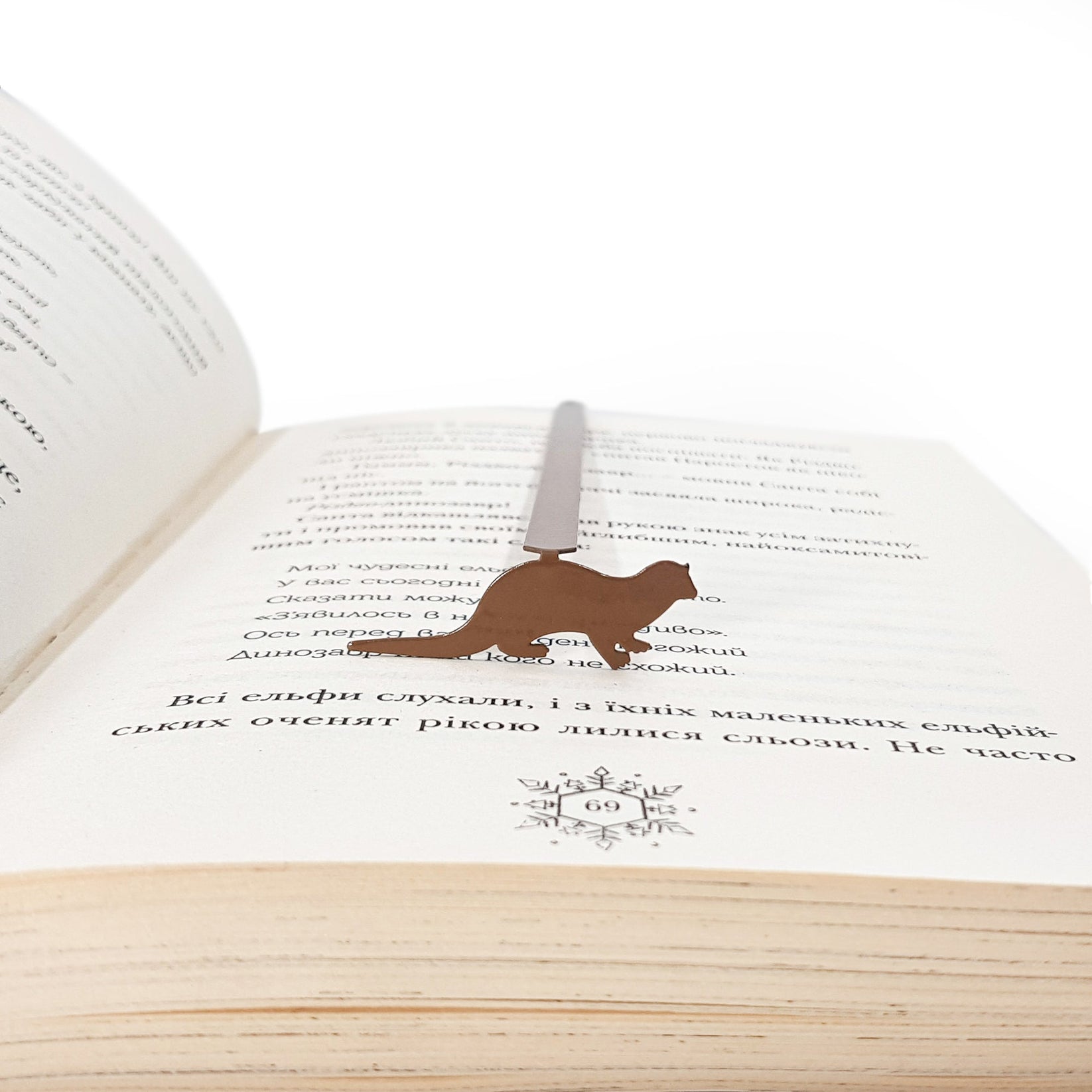 Otter bookmark resting on the pages of an open book