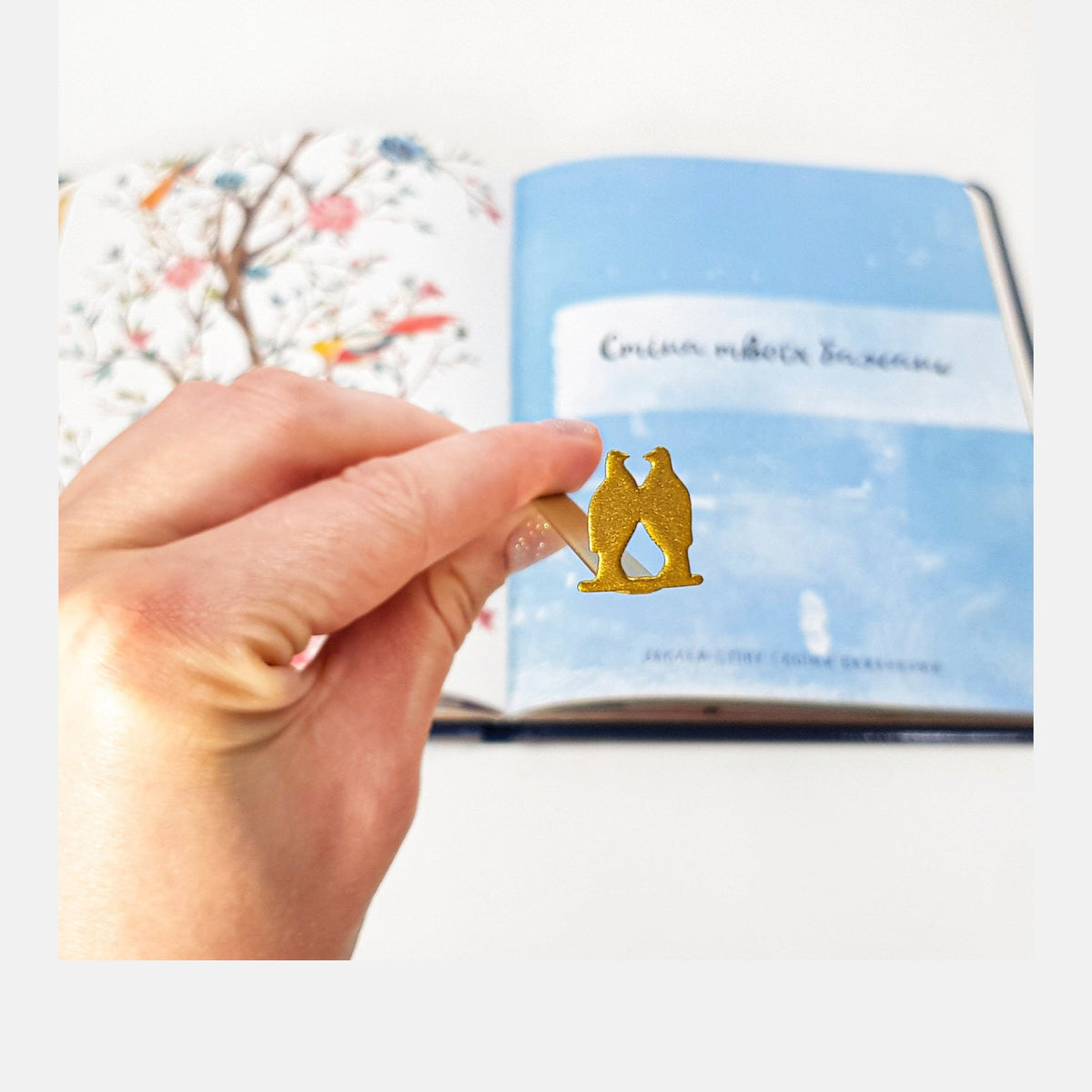 Pair of Pigeons metal bookmark marking a page in an illustrated book