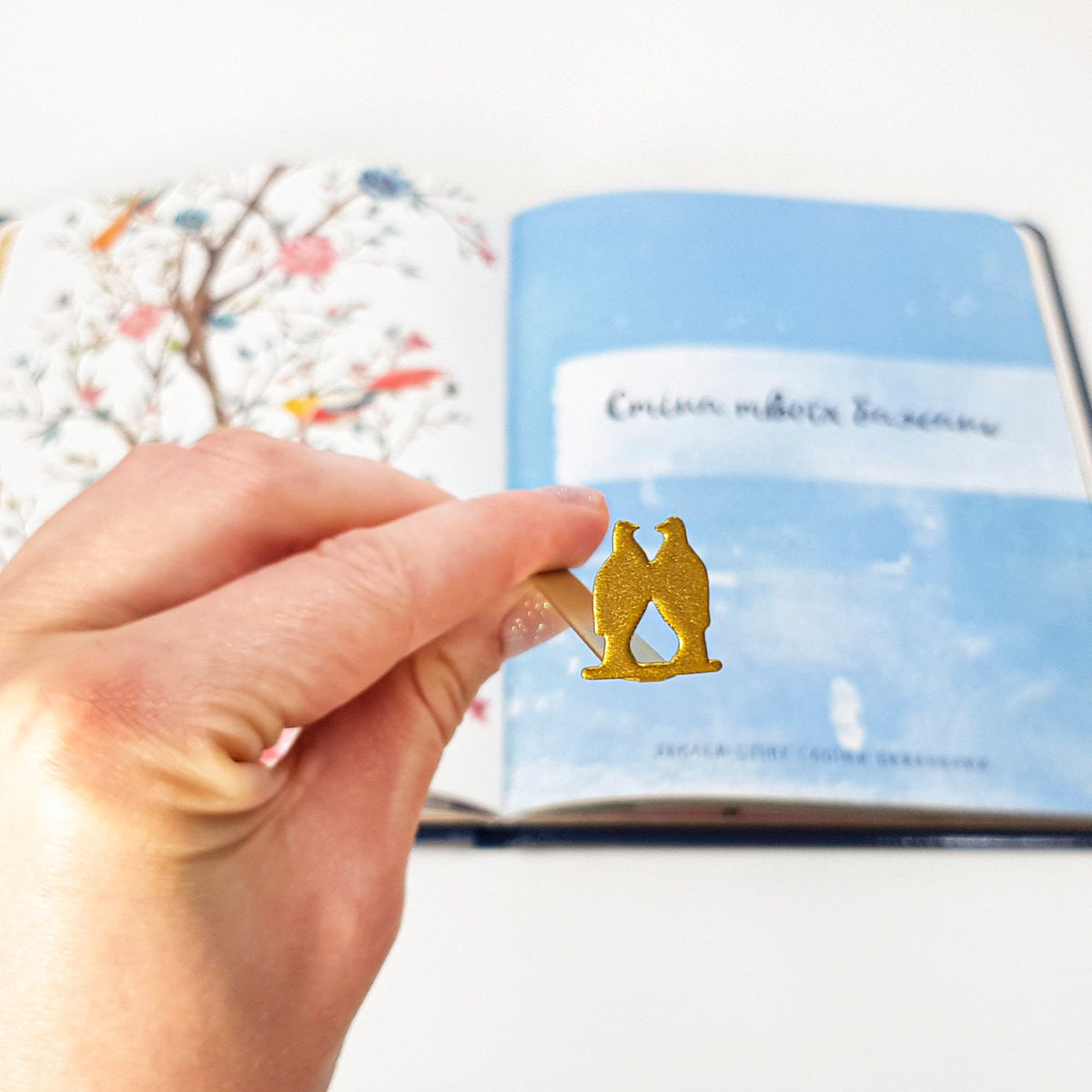 Pair of Pigeons metal bookmark marking a page in an illustrated book