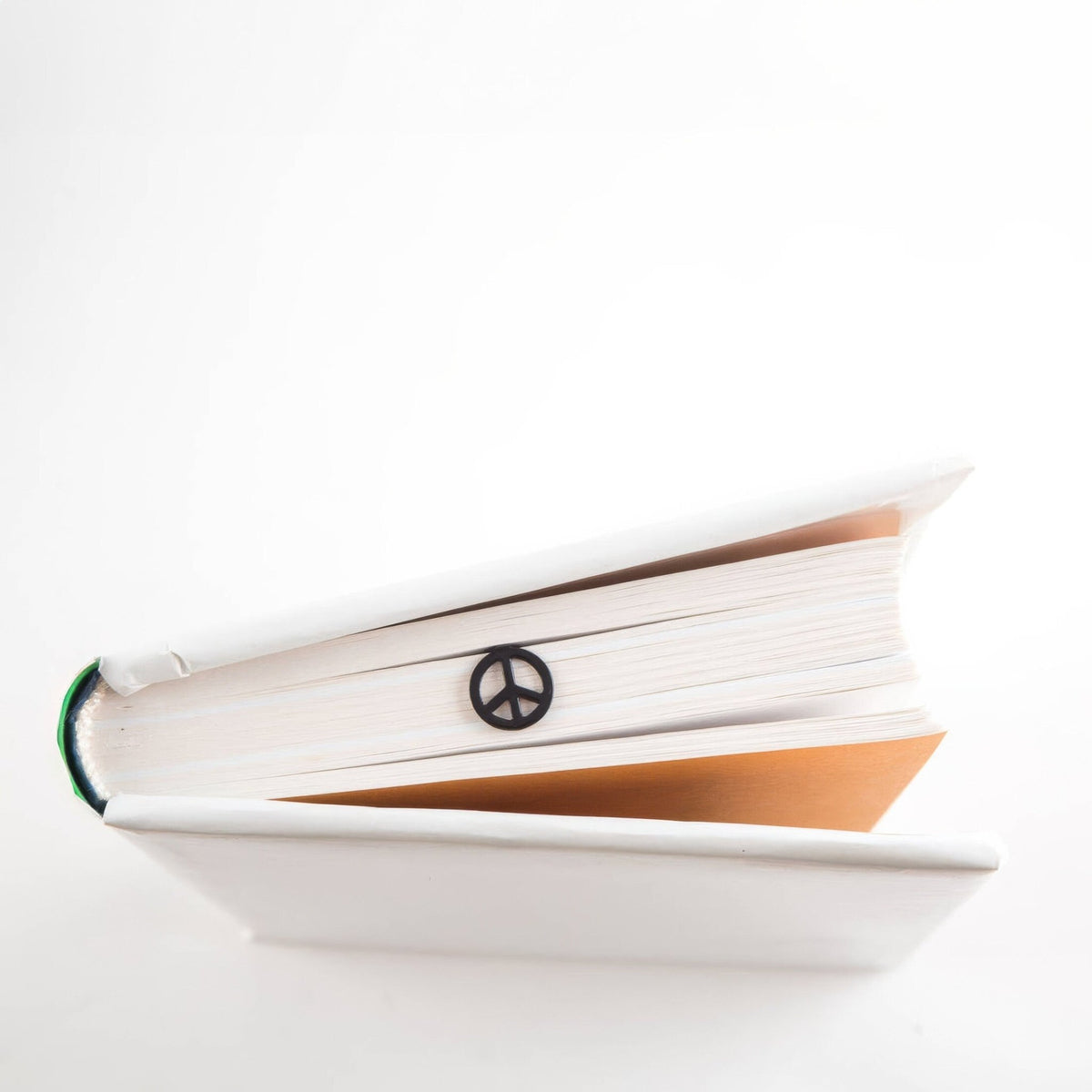 Peace metal bookmark marking a page in an open book