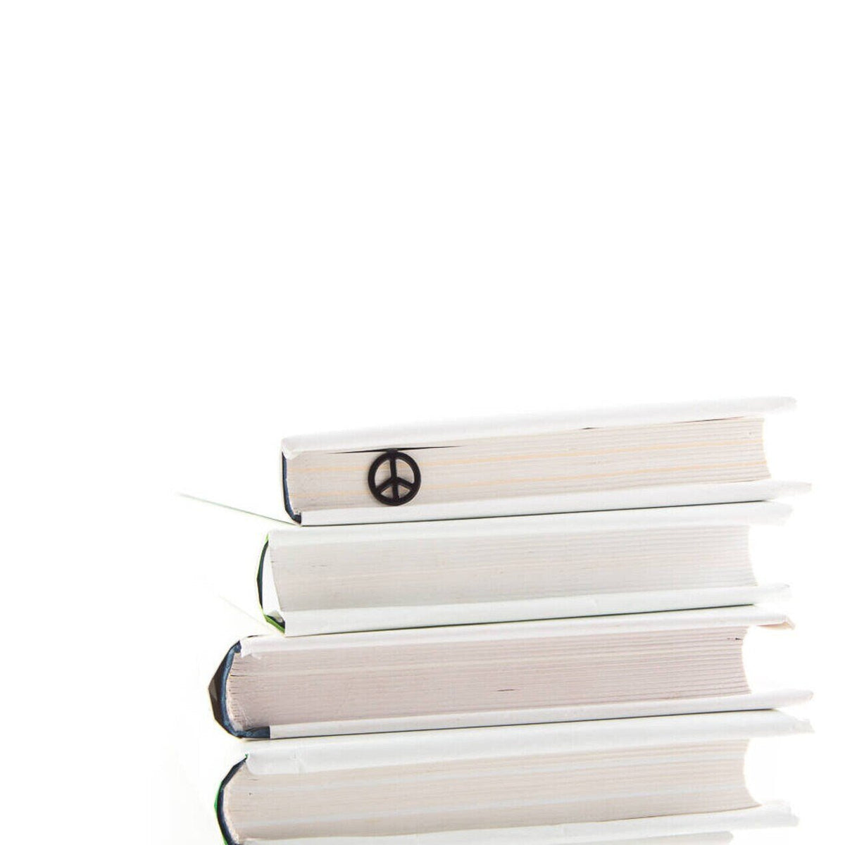 Peace metal bookmark lying on a stack of white books